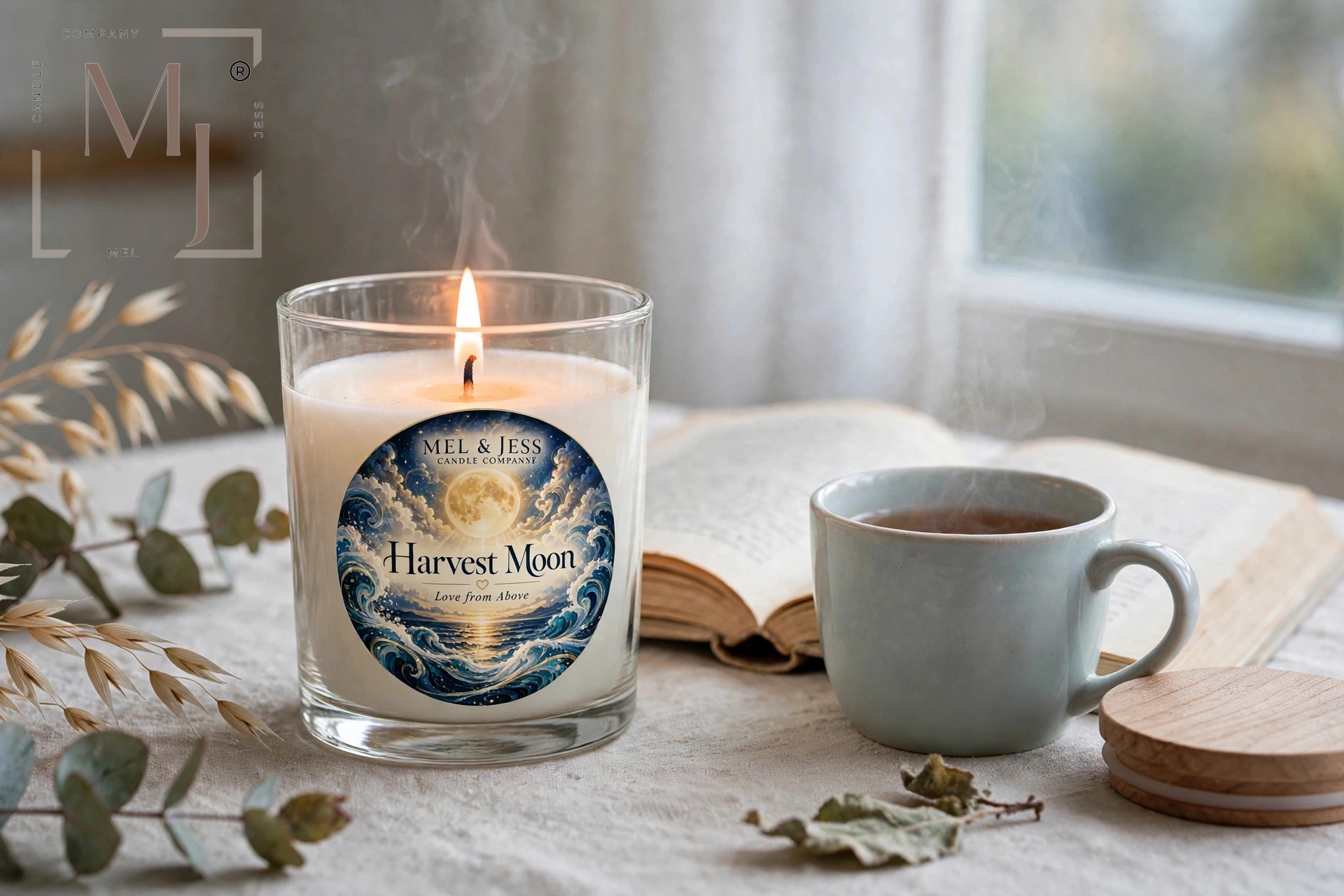 Mel & Jess Harvest Moon candle glowing beside an open book and warm drink